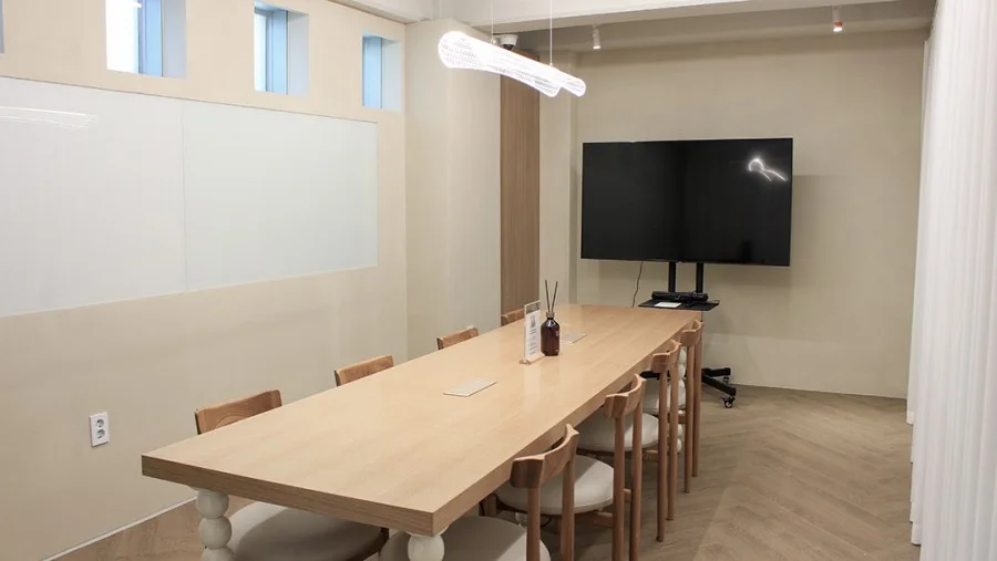 무브먼트 강남 회의실 — 긴 나무 테이블과 모니터